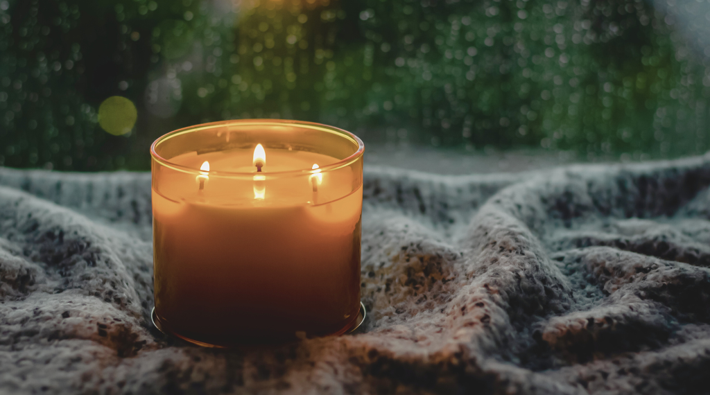 Świeca zapachowa stojąca na stole w domu, tworząca przytulną atmosferę.