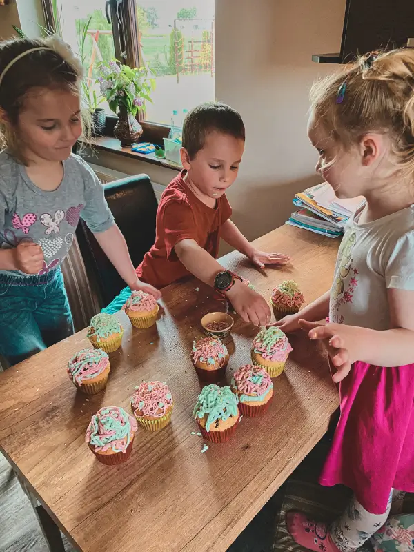 Dzieci dekorujące babeczki na Dzień Babci i Dziadka