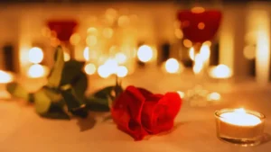 Romantyczna dekoracja stołu na Walentynki z czerwonymi różami i zapalonymi świecami