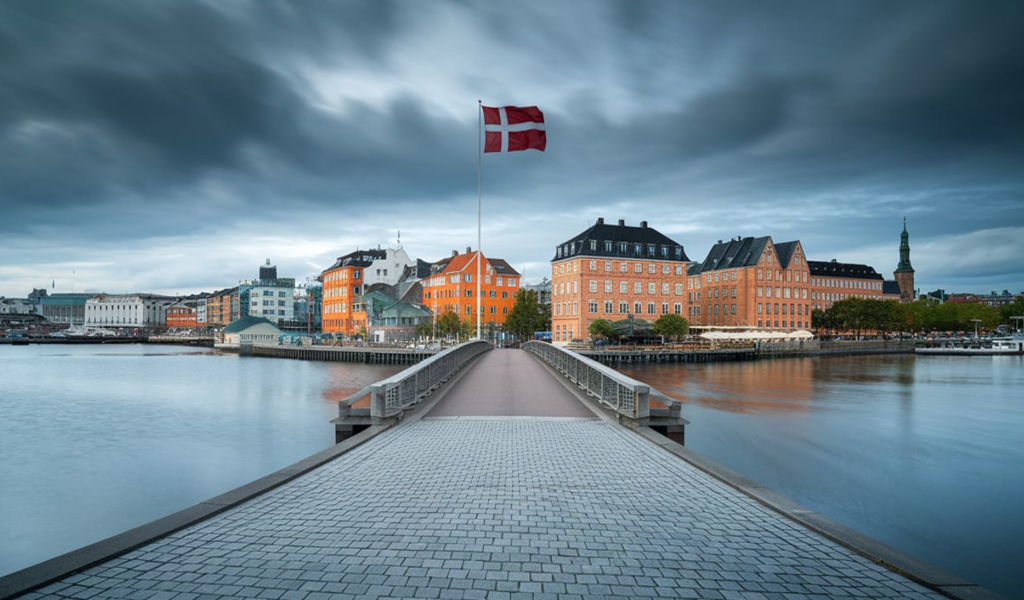 Praca Dania na zdjęciu flaga Danii na tle pieknego miasta dunskiego