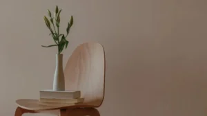 Minimalistyczny detal wnętrza – książki i wazon na krześle