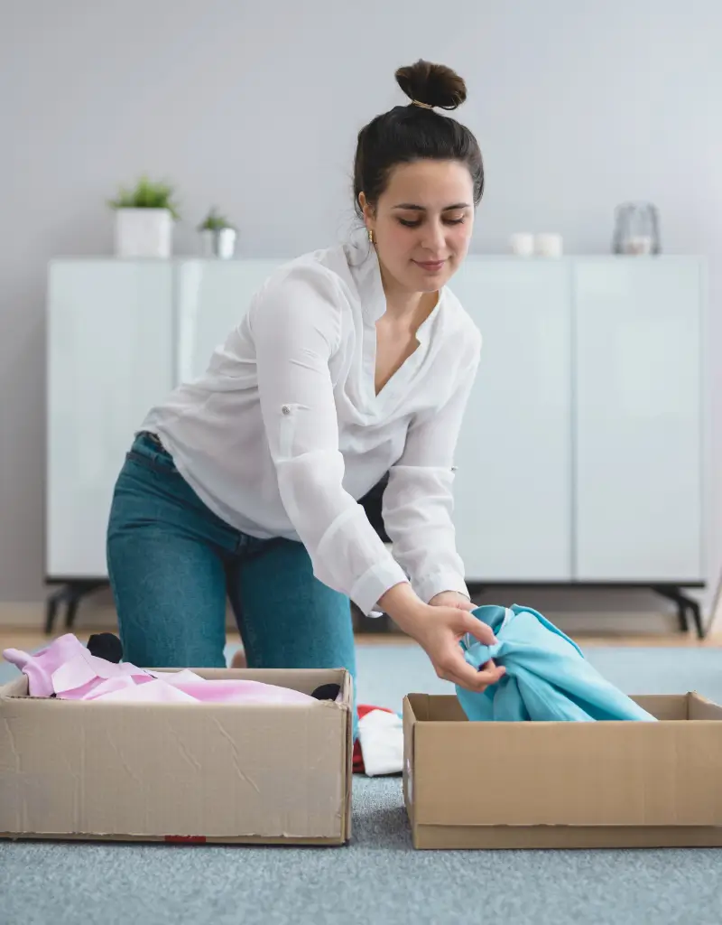 Minimalizm w szafie – kobieta dzieli ubrania na te, które zostają i te, których już nie używa