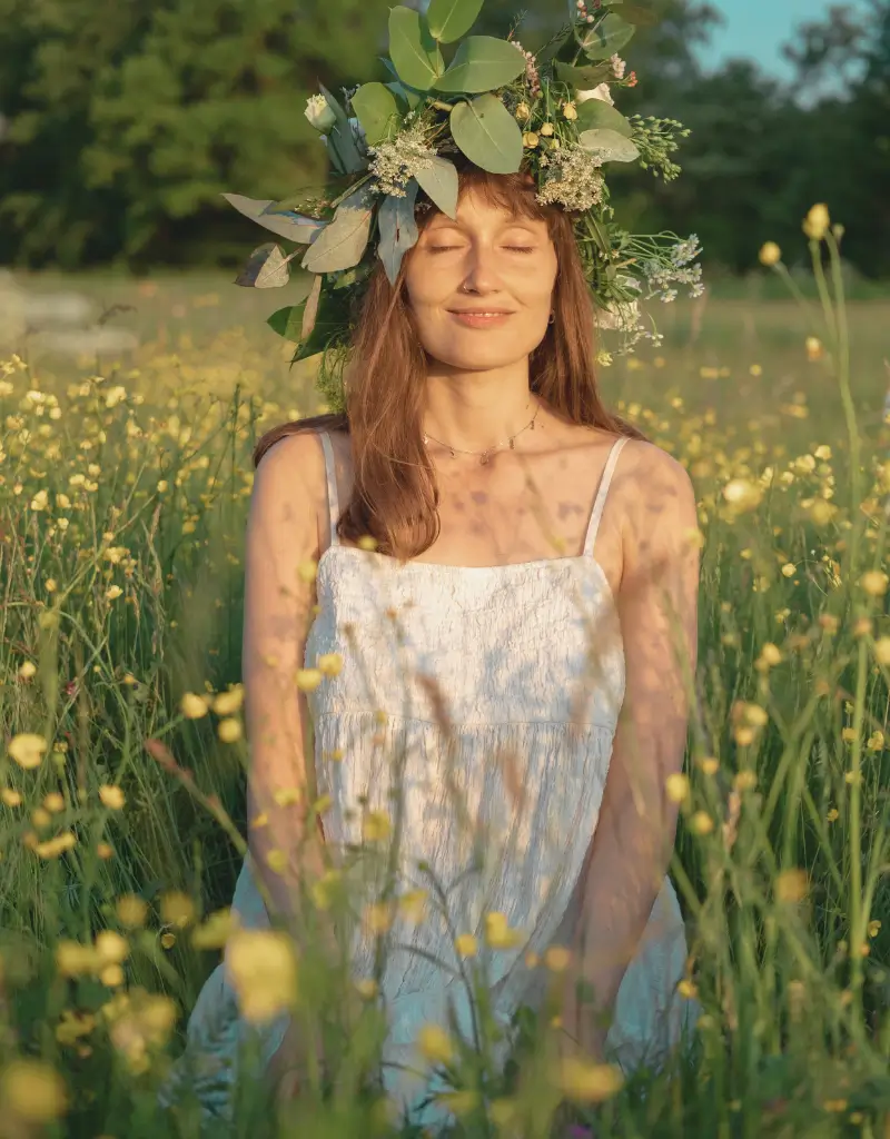 Kobieta w wianku stojąca na łące w słoneczny dzień, inspirowana świętem Beltane, w stylu impresjonistycznego obrazu