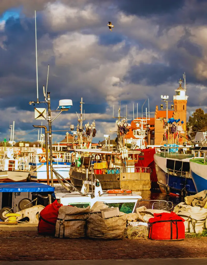 Widok na latarnię morską w Ustce z perspektywy portu, w jesiennym świetle