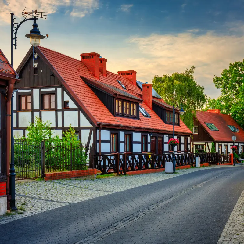 Zabytkowe domy ryglowe w Ustce z białą elewacją i brązowymi belkami – przykład lokalnej architektury nadmorskiej