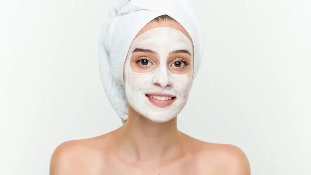 Kobieta nakłada maseczkę na twarz w ramach pielęgnacji skóry.