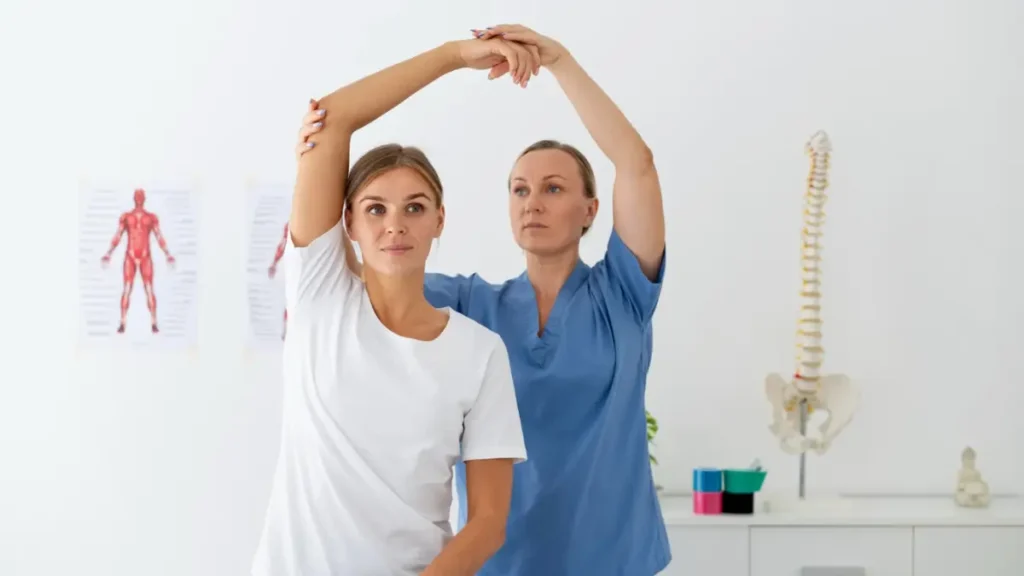 Fizjoterapeuta rozmawia z pacjentem w gabinecie rehabilitacji w Gnieźnie – konsultacja i terapia ruchowa w przyjaznej atmosferze.