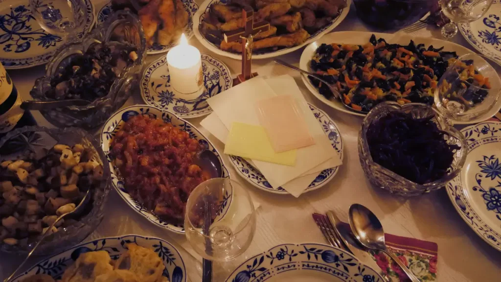 Stół wigilijny z tradycyjnymi potrawami – 12 potraw wigilijnych, świece i dekoracje