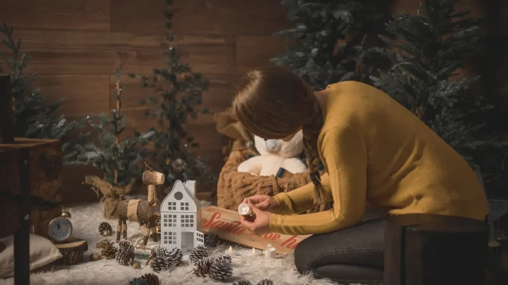 Kobieta kucająca i przeglądająca świąteczne dekoracje podczas spokojnych, domowych przygotowań do świąt.