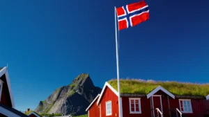 czerwone domy w Norwegii i flaga norweska – koszty podróży i życia
